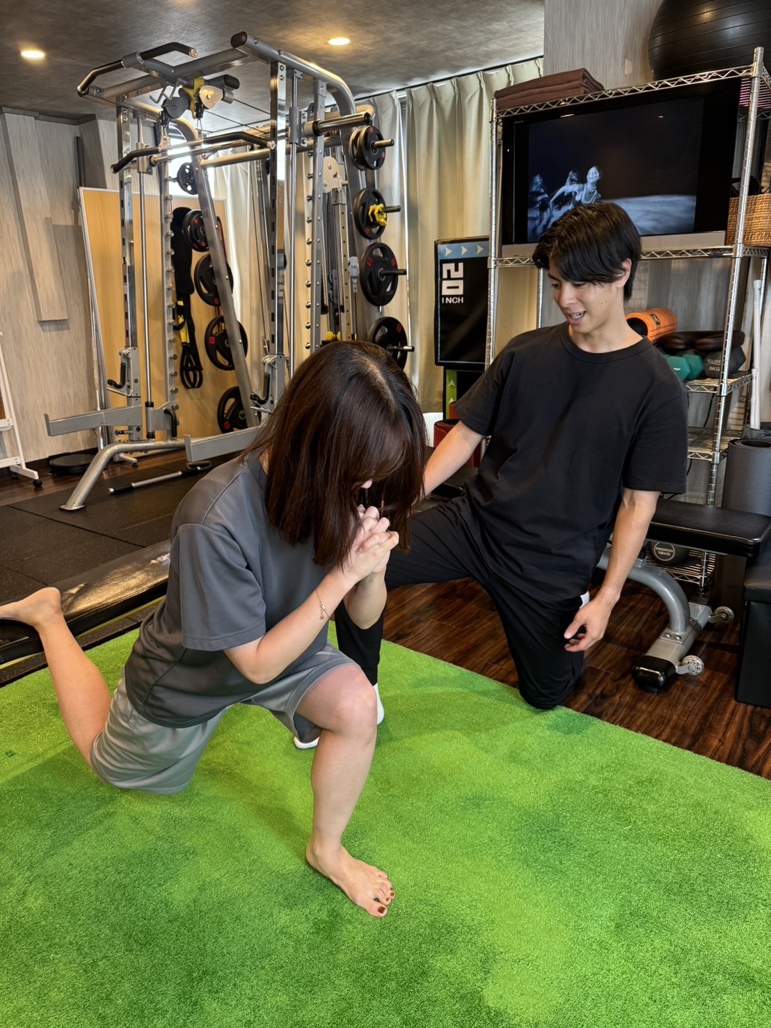 BREEZE高槻店で女性のお客様へマンツーマントレーニングを行う様子